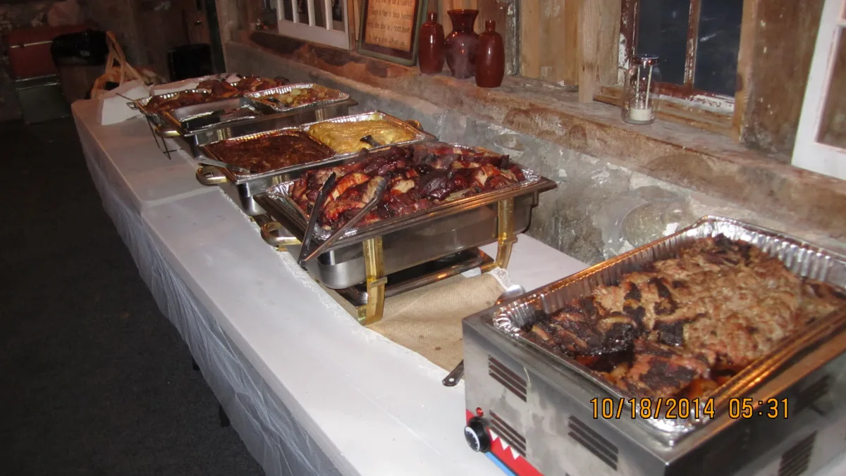 A buffet with barbecue meats and sides set for an event